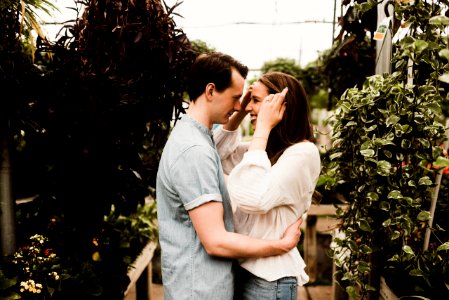 man holding waist of woman surrounded plants
