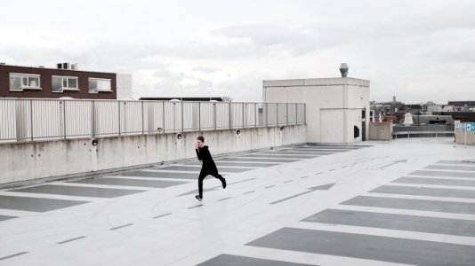 person running on concrete lot during daytime photo