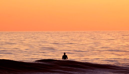 silhouette of person in body of water