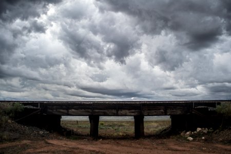 brown wooden bench under cloudy sky during daytime photo