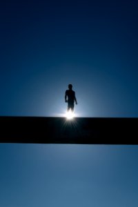 silhouette of man standing on bridge