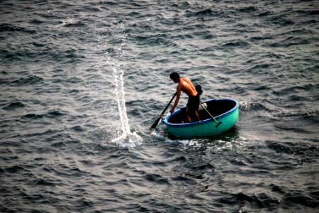 man riding on round green boat at daytime