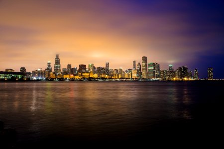 city skyline near body of water during golden hour photo