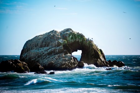 photo of sea wave crashing into boulder photo