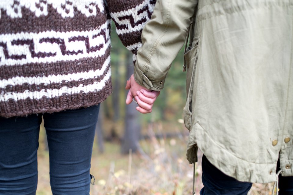 two persons holding each other's hands