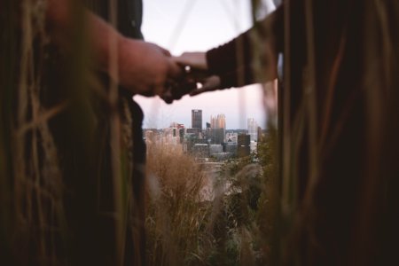 couple holding hands in a distance of city photo