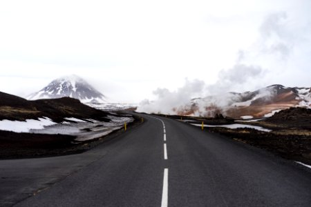 concrete road with snow-capped mountain at distance photo