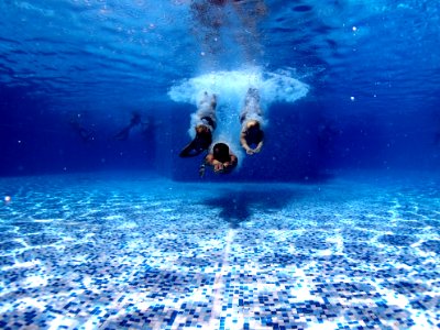 three person diving on water photo