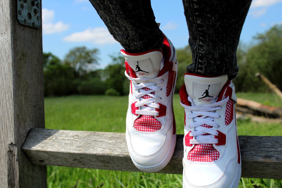 person wearing pair of red-and-white Air Jordan shoes