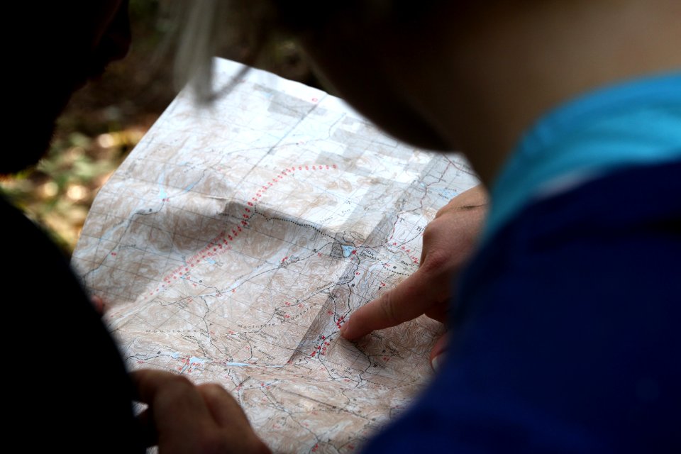 person pointing on beige map