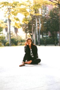 woman in black jacket while sitting on floor