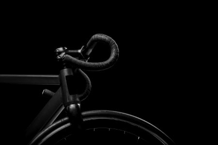 black road bicycle handle with black background photo