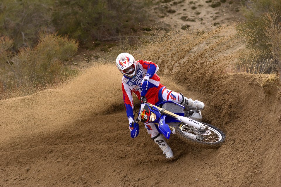 racer riding motocross dirt bike running on brown dirt
