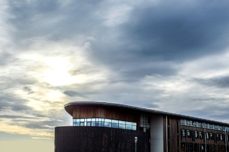 black and brown concrete building under gray cloudy sky photo