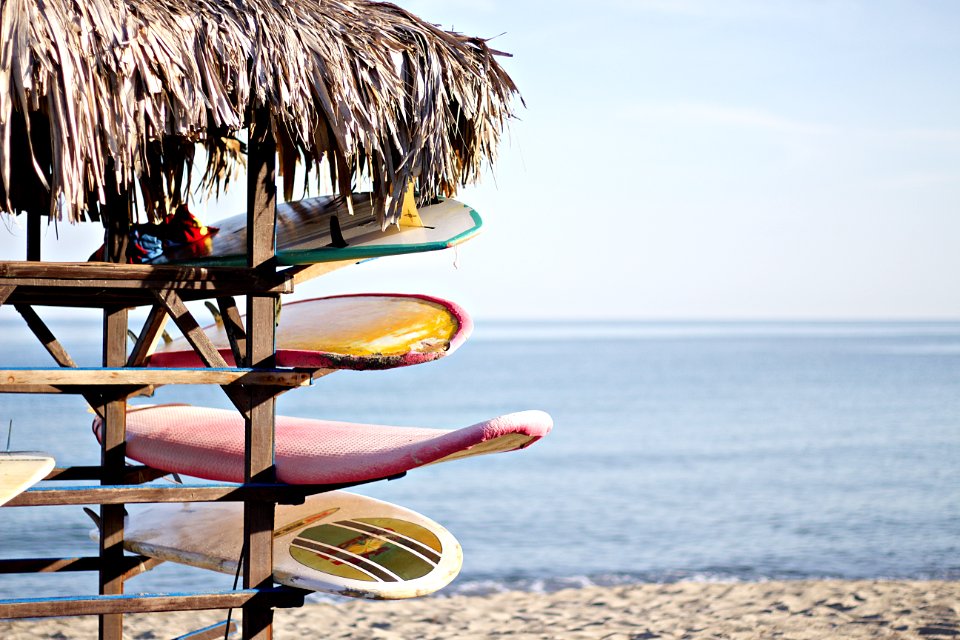red and white surfboard in brown wooden rack