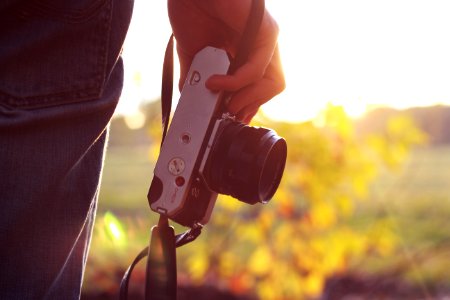 person holding bridge camera during daytime