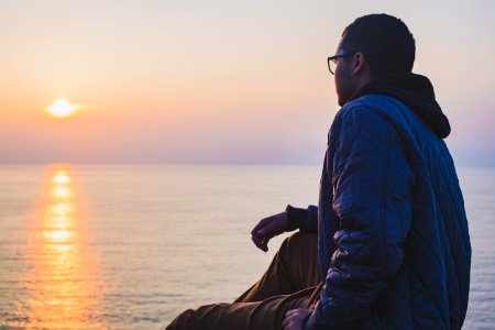 man sitting near body of water
