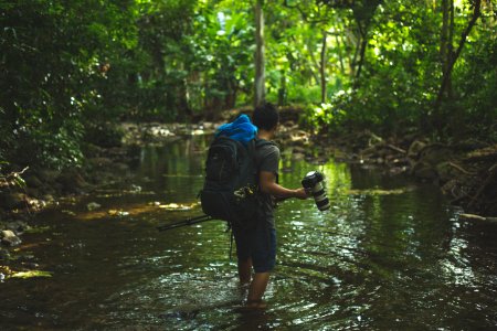 shallow focus photography of man walking in river photo