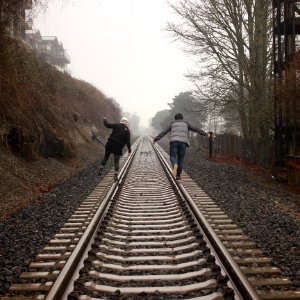 two person walking on the train rail photo