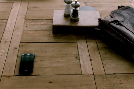 black smartphone beside brown leather bag photo