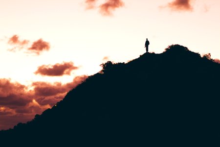 photo of man standing on top of mountain photo
