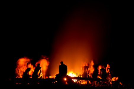 people gathered around camp fire at nighttime photo