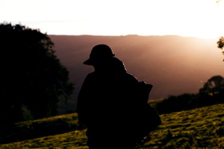 silhouette photo of person carrying backpack during daytime