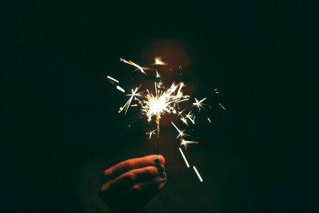 person holding lighted sparkler photo