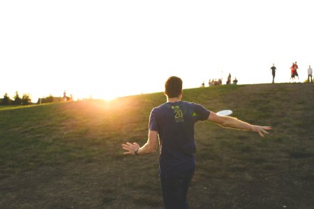 man walking on green grass field photo