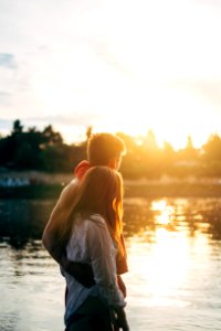 couple walking on lake side watching sunset close-up photo