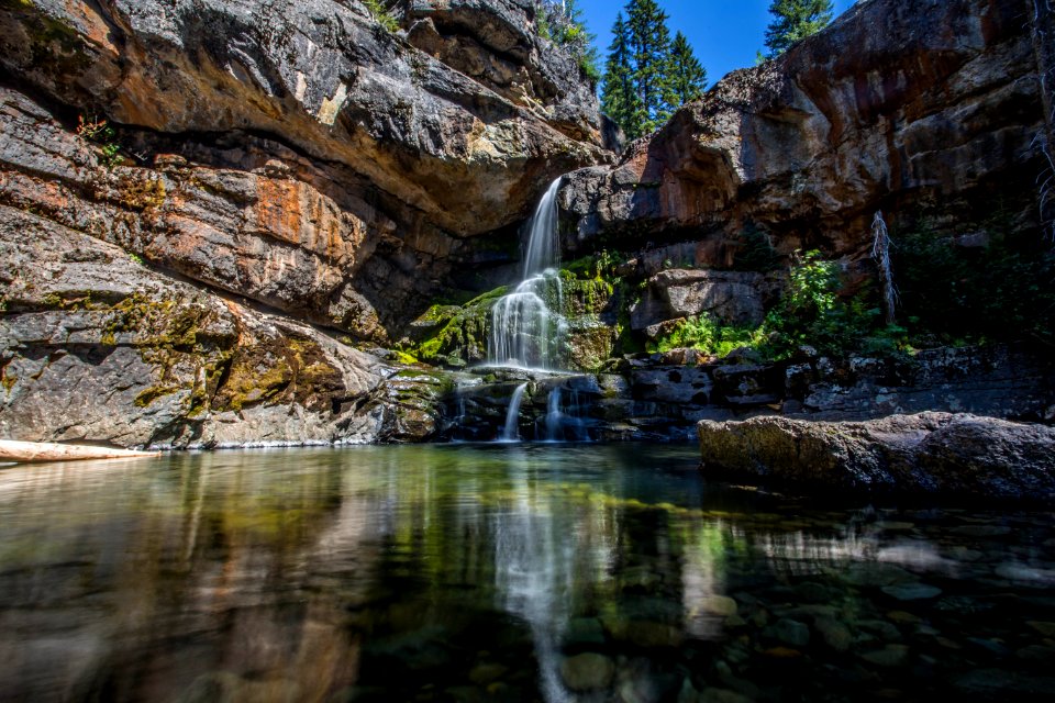 water falls in between brown rocks