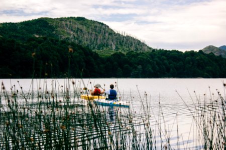 two person kayaking near mountain