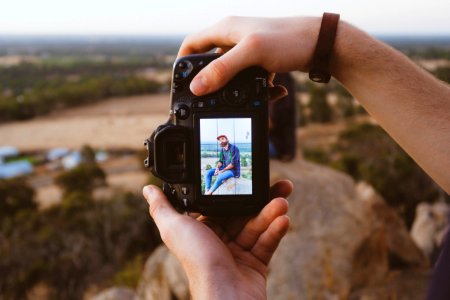 person using black DSLR camera photo