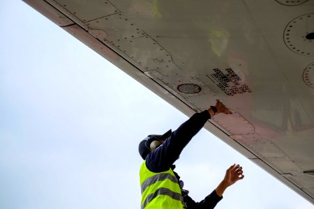 man in green safety vest standing under white structure photo