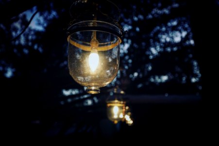 selective focus photography of lighted clear glass lamp on tree