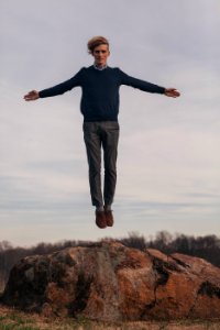 man jumping while open arms photo