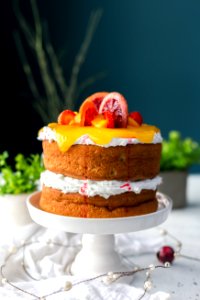 two-layered cake with citrus fruit and strawberry toppings