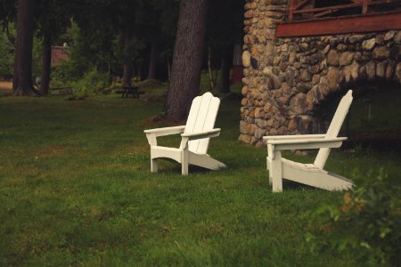 two white wooden armchairs on grasses photo