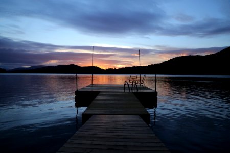 wooden dock at the lake during sunset