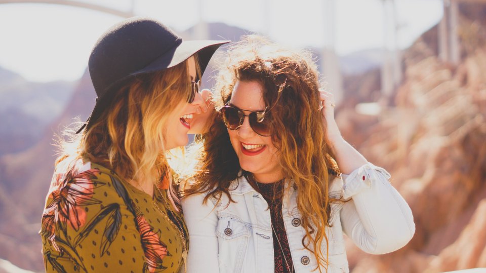 two women smiling while wearing sunglasses photo