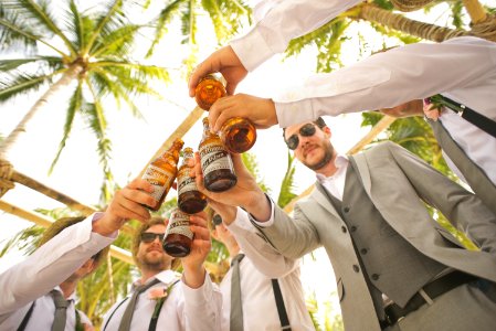 low angle of men holding beer bottles and having a toast photo