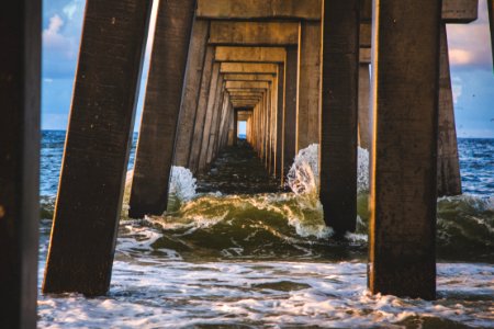 sea waves under brown concrete dock at daytime photo