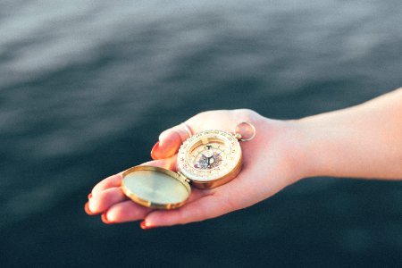person holding gold-colored pocket watch photo