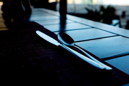 two stainless steel spoon beside knife on table photo