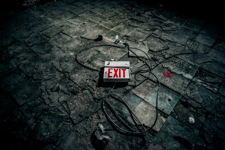 grey exit sign board on grey pavement