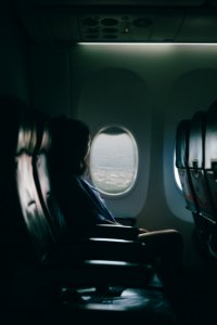 woman sits on seat near window inside plane photo