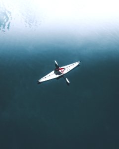 man in kayak on body of water during daytime photo