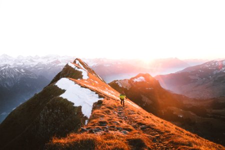 A person walking on a rocky path along the mountain ridge photo