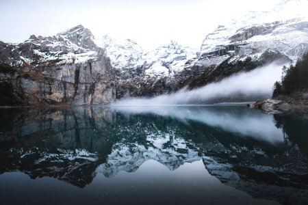 snow covered mountain near reflecting on water during daytime photo