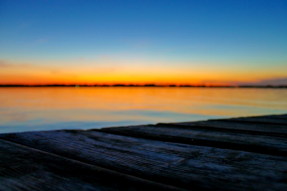 selective focus photo of brown wood planks in front of beach during golden hour